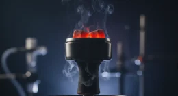 Крупный план раскалённых углей в калауде на чаше кальяна, с акцентом на жар и лёгкий дым.