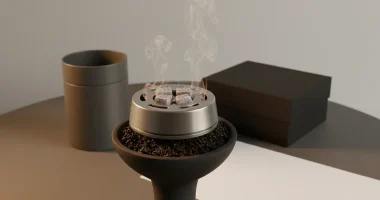 Крупный план кальянной чаши с забитым чайным листом и устройством для контроля жара, над которым поднимается лёгкий пар