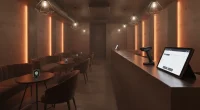 Внутри современной кальянной с 2D-сканером и планшетом на барной стойке, символизирующими внедрение системы «Честный зна