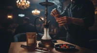 Руки кальянщика в стильной московской кальянной, готовящего кальян. Фокус на деталях процесса, размытый фон интерьера.