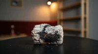 Крупный план кальянного угля с пеплом и искрами на фоне размытой кальянной