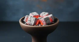 Крупный план кальянной чаши с неравномерно горящими углями и большим количеством пепла