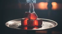 Раскаленные угли для кальяна на металлической сетке в полумраке