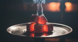 Раскаленные угли для кальяна на металлической сетке в полумраке
