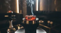 Крупный план горящих углей на устройстве управления жаром в чаше кальяна