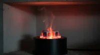 Крупный план раскаленного кальянного угля на электрической плитке, окруженного легкой дымкой, символизирующей угарный га